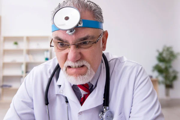 Old male doctor otologist working in the clinic — Stock Photo, Image
