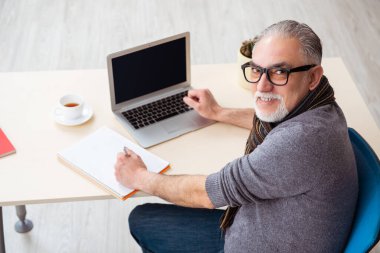 Salgın sırasında evde çalışan yaşlı bir erkek işçi.