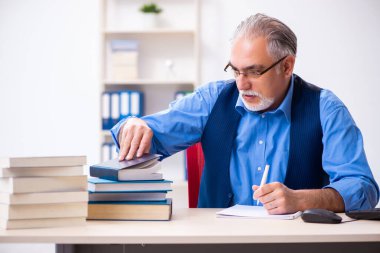 Kitap yazan yaşlı bir erkek yazar.