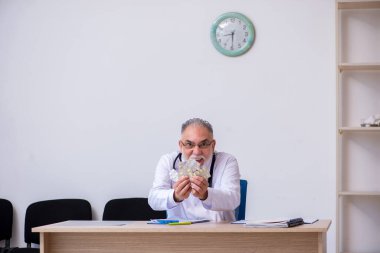 Klinikte çalışan yaşlı erkek doktor.