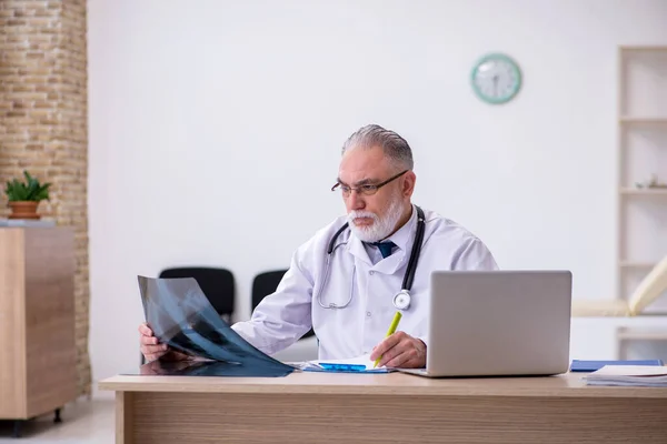 Oude mannelijke arts werkzaam in de kliniek — Stockfoto