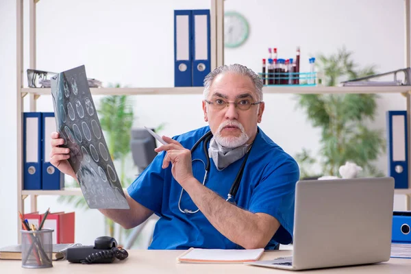 Gammal manlig läkare som arbetar på kliniken — Stockfoto