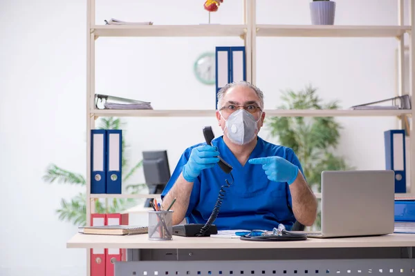 Vieux médecin masculin travaillant à la clinique — Photo