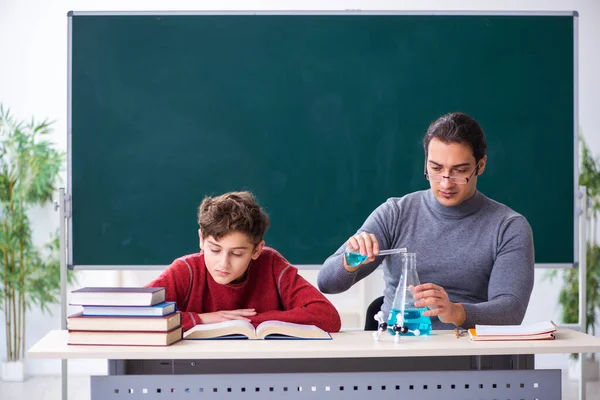 Jonge mannelijke leraar en schooljongen in de klas — Stockfoto