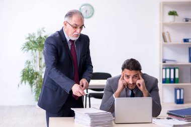 Eski patron ve genç asistanı ofiste çalışıyor.