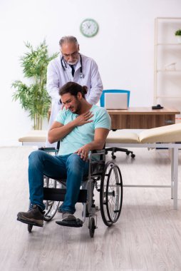 Tecrübeli doktor ve tekerlekli sandalyedeki genç hasta.