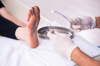 Erkek doktor travmatoloğu ziyaret eden yaralı bir kadın.
