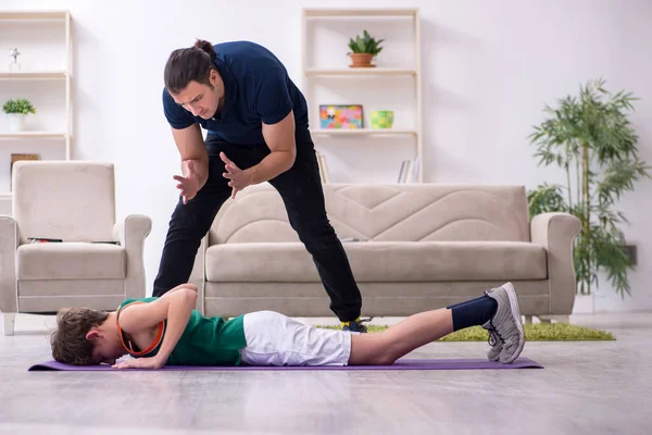 Pai e filho fazendo exercícios esportivos dentro de casa — Fotografia de Stock