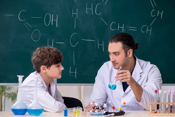 Joven profesor de química y colegial en el aula —  Fotos de Stock