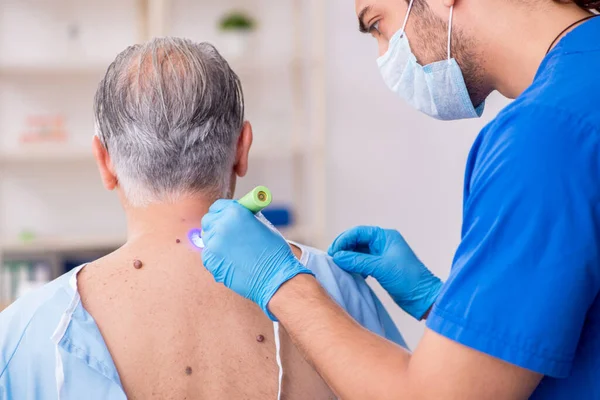 Starý muž návštěva mladý lékař dermatolog — Stock fotografie