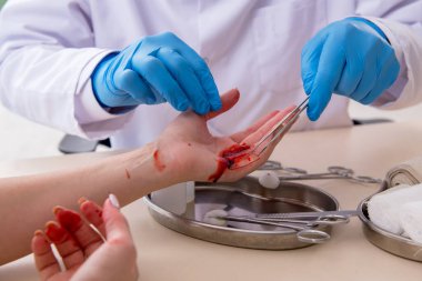 Yaralı kadın erkek doktoru ziyaret ediyor.