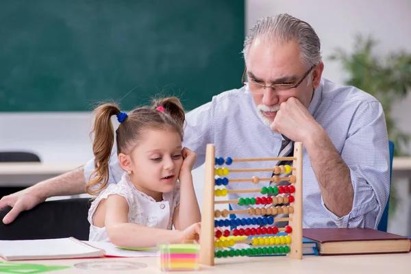 Oude leraar en schoolmeisje op school — Stockfoto