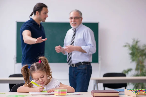 Ung förälder, gammal manlig lärare och liten flicka i klassrummet — Stockfoto