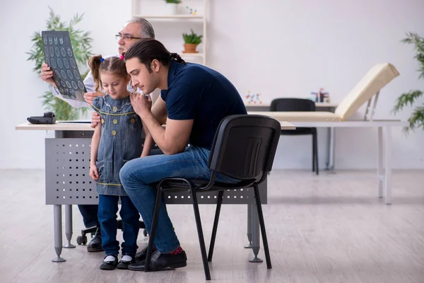 Junger Vater und seine Tochter zu Besuch beim alten Arzt — Stockfoto