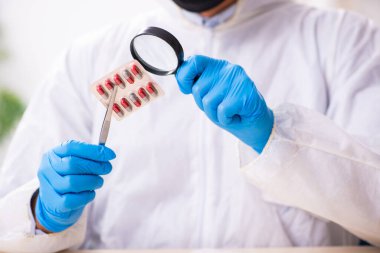 Erkek kriminolog kanıt için laboratuarda çalışıyor.