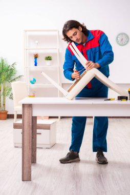 Genç erkek marangoz içeride çalışıyor.