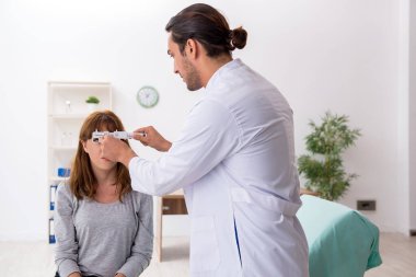 Genç bir kadın, erkek doktoru ziyaret ediyor.