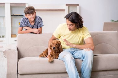 Genç baba ve oğlu cocker spaniel köpeğiyle