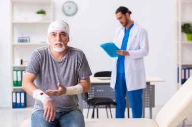 İlk yardım konseptinde genç erkek doktor ve yaşlı hasta.