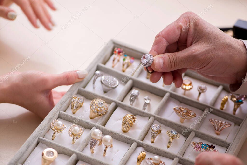 Young woman visiting old male jeweler