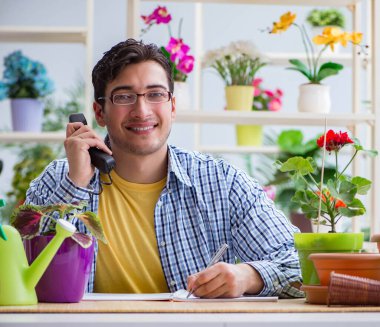 Çiçekçide çalışan genç adam.