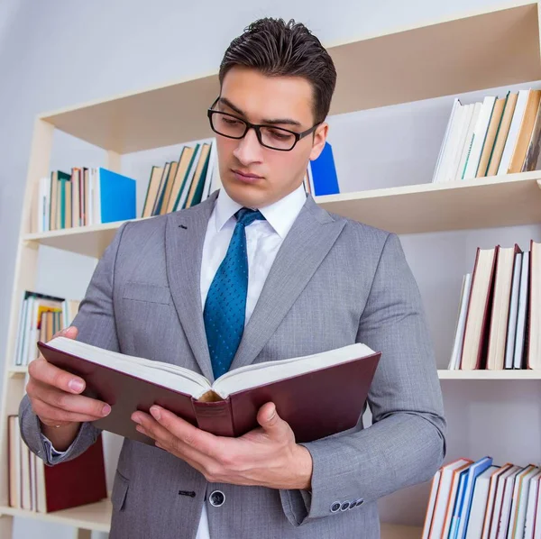 Estudante de negócios lendo um livro estudando na biblioteca — Fotografia de Stock