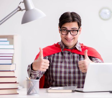 Dizüstü bilgisayarı olan süper kahraman öğrenci sınavlara hazırlanıyor.