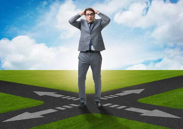 Young businessman at crossroads in uncertainty concept — Stock Photo, Image