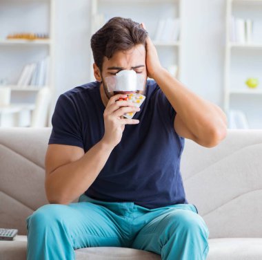 Genç adam estetik cerrahi burnundan sonra evde iyileşiyor.