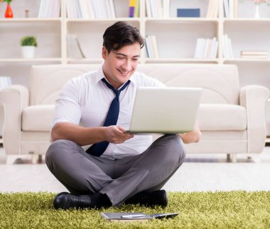 İş adamı ofiste yerde oturuyor.