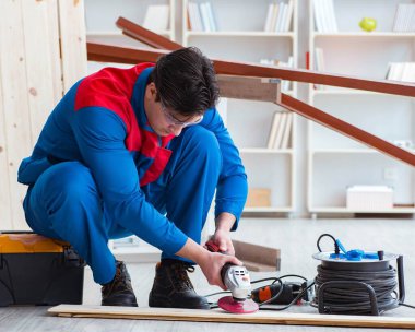 Genç marangoz ahşap kalaslarla çalışıyor.