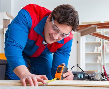 Genç marangoz tahta kalaslarla çalışıyor.