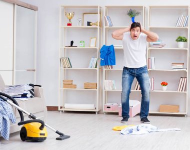Adam evi temizliyor.