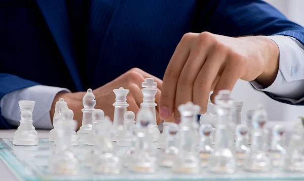 Jovem empresário jogando xadrez de vidro no escritório — Fotografia de Stock