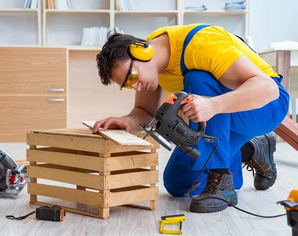 Reparador carpintero cortando aserrar una tabla de madera con un electr — Foto de Stock