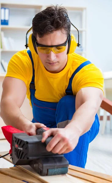Repairman carpenter polishing a wooden board with an electric po — Stock Photo, Image