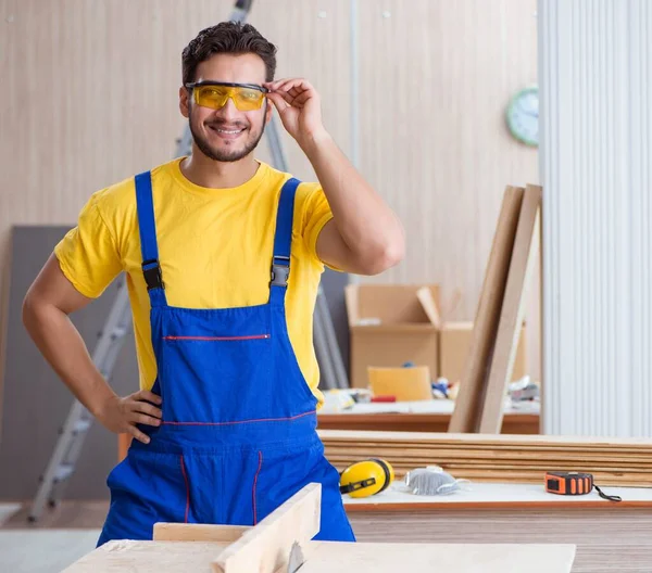 Il giovane carpentiere riparatore lavora il legno da taglio su assi circolari — Foto Stock