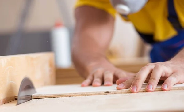 Il giovane carpentiere riparatore che lavora con una sega circolare — Foto Stock