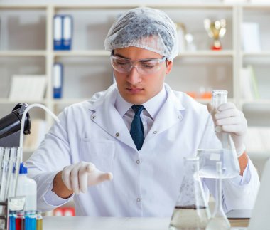 Genç araştırmacı bilim adamı bir su testi kirliliği araştırması yapıyor.