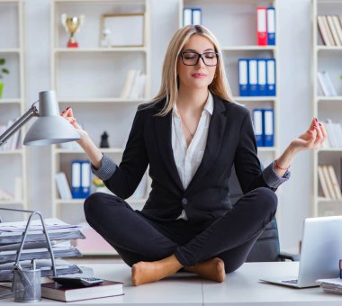 İş kadını ofiste meditasyon yaparken hayal kırıklığına uğradı