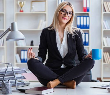 İş kadını ofiste meditasyon yaparken hayal kırıklığına uğradı