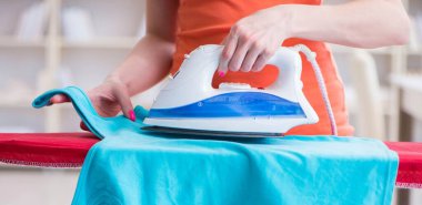 Kadın karısı evde ütü yapıyor.