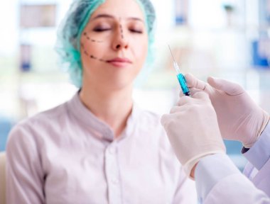 Estetik cerrah kadın yüzü ameliyatına hazırlanıyor