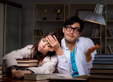 İki öğrenci geç saatlere kadar çalışıp sınavlara hazırlanıyor.