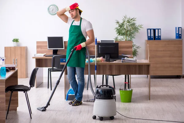 Jonge mannelijke aannemer schoonmaken van het kantoor — Stockfoto