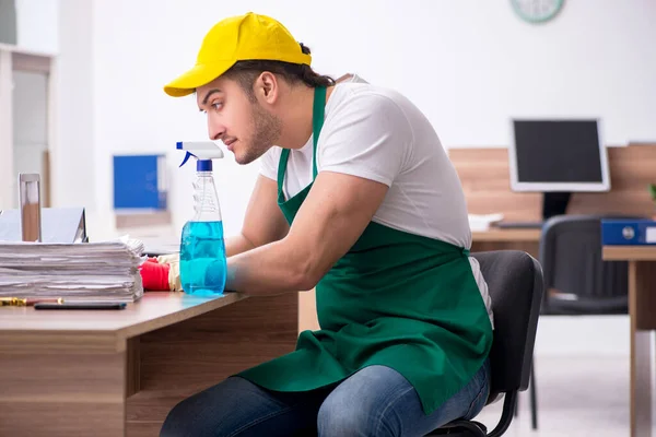 Young male contractor cleaning the office