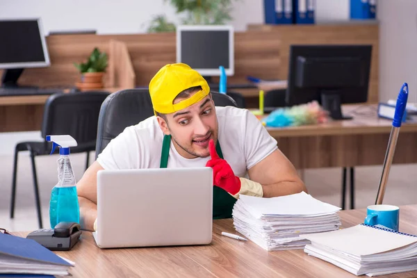 Junge männliche Auftragnehmer putzen das Büro — Stockfoto