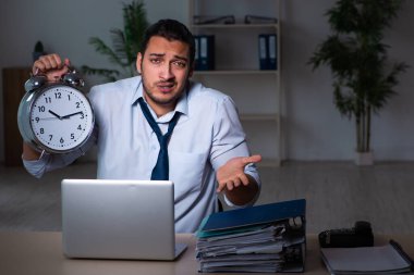 Genç işadamı ofiste geç saatlere kadar çalışıyor.