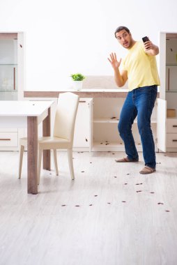 Genç adam ve evde bir sürü hamamböceği var.