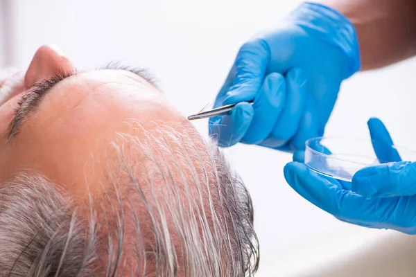 Old man visiting young male doctor in hair transplantation conce — Stock Photo, Image